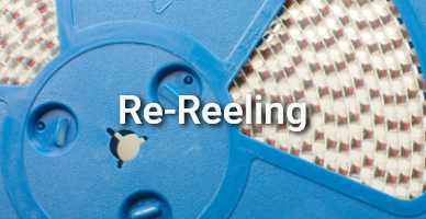 Nahaufnahme einer blauen Bauteilrolle mit aufgewickelten elektronischen SMD-Komponenten; mittig steht der Schriftzug „Re-Reeling“ – ein Service von Schukat. Nahaufnahme einer blauen Bauteilrolle mit aufgewickelten elektronischen SMD-Komponenten; mittig steht der Schriftzug „Re-Reeling“ – ein Service von Schukat.