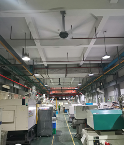 Produktionshalle mit Spritzgussmaschinen und an der Decke installierten SUNON HVLS-Ventilatoren zur energieeffizienten Luftzirkulation und Kühlung. Produktionshalle mit Spritzgussmaschinen und an der Decke installierten SUNON HVLS-Ventilatoren zur energieeffizienten Luftzirkulation und Kühlung.